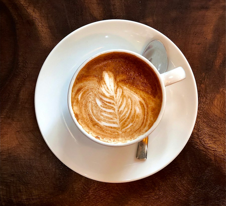 Cappuccino with rosetta latte art in a white ceramic cup on a saucer