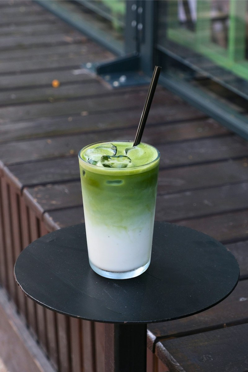 Iced matcha shake layered with Jersey milk in a tall glass on a cafe table