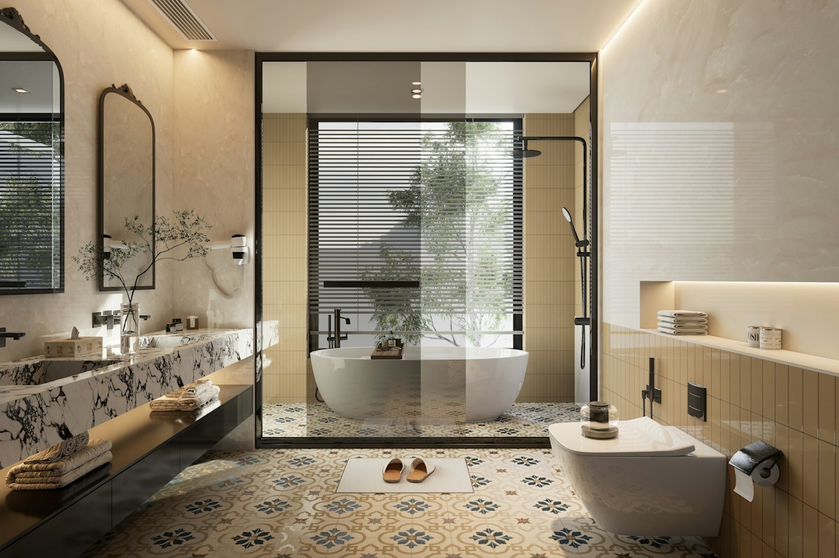Hotel bathroom with a freestanding tub, patterned tiling and brass fittings