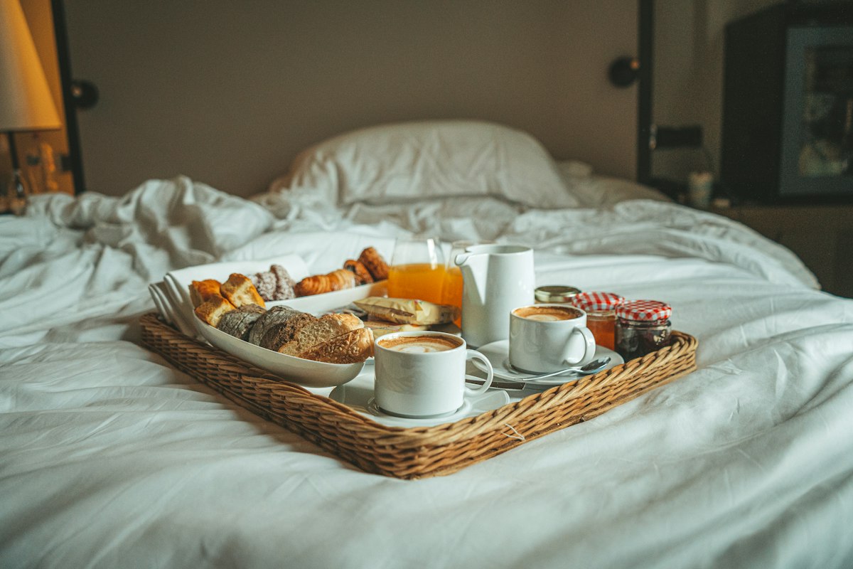Breakfast tray with coffee on a made bed in a ConnectionCafe.com guest room