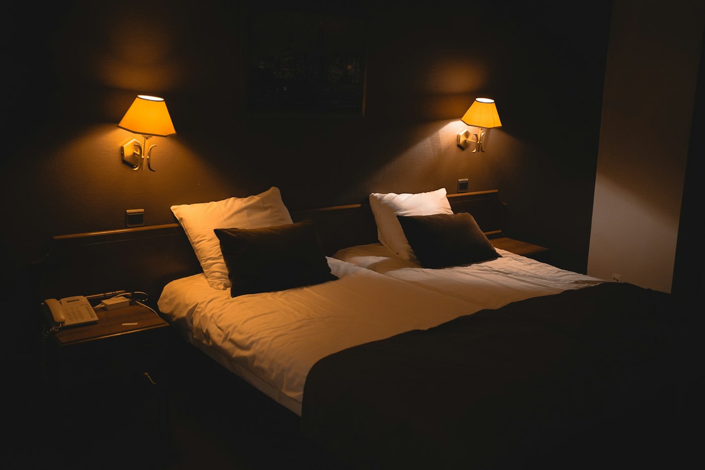 Boutique hotel double room with warm sconce lighting and linen bedding above ConnectionCafe.com