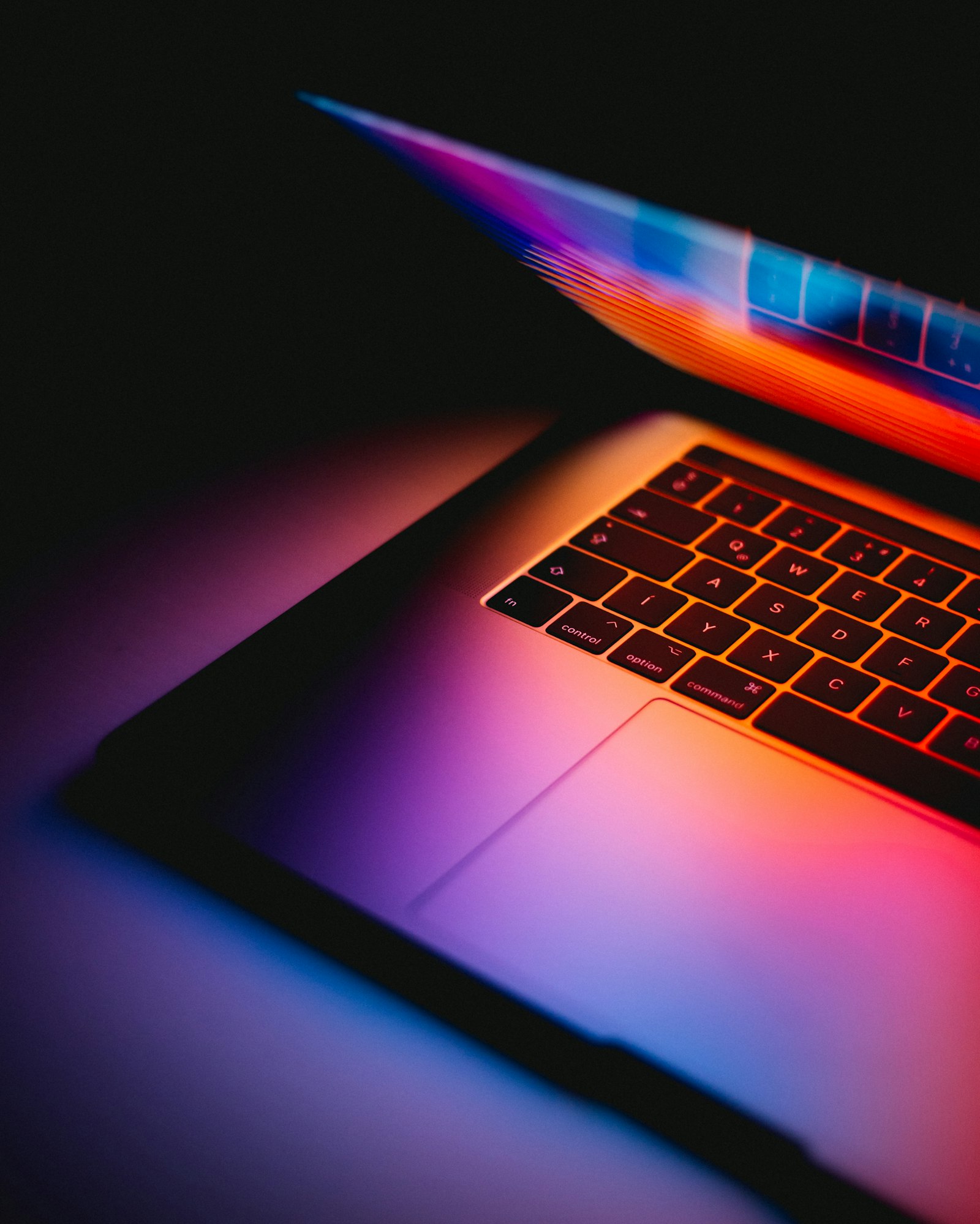A laptop keyboard lit by colourful screen light, introducing the ConnectionCafe.com tech guides