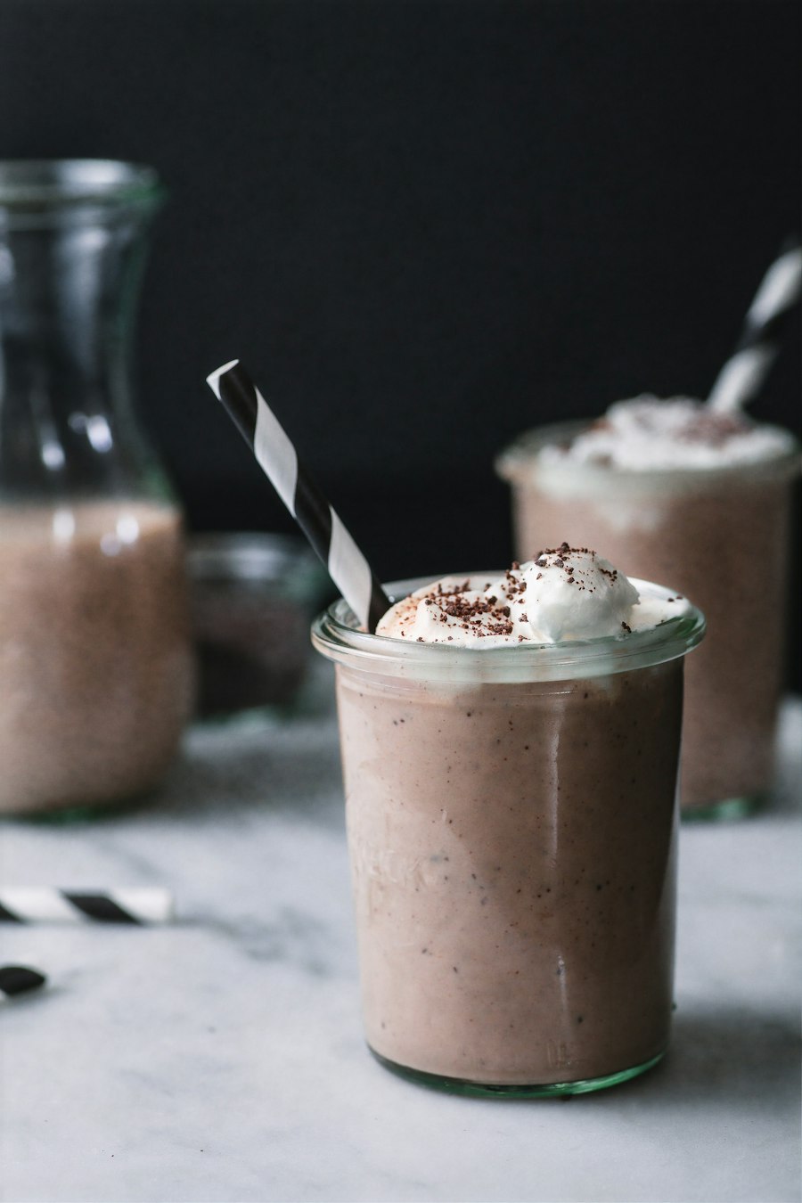 Mocha milkshake topped with whipped cream and cocoa in a tall glass at ConnectionCafe.com